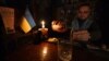 A bartender pours a drink by candlelight during a power cut at a bar in the center of Ukrainian capital of Kyiv. 