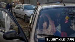 A Ukrainian woman sits in a car in Zaporizhzya with her family after they managed to flee from the Russian-occupied territory of Kherson on November 5.