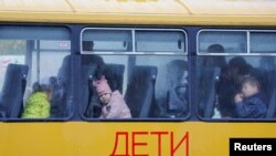 2022-nji ýylyň oktýabr aýynyň ahyrynda Russiýanyň gözegçiligindäki Herson şäherinden göçürilen çagalar Kryma barýan awtobusda garaşýarlar.