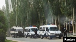 Kaşgaryň köçesinde duran polisiýa gullukçylary hem olaryň awtoulaglary. 2021-nji ýylyň 4-nji maýy.