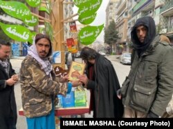 استاد مشعل کتاب های شخصی خود را در یک کراچی دستی جابجا کرده بود و آن را میان مردم در کابل به صورت رایگان توزیع میکرد