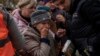 An elderly woman reacts after receiving food donations in Kherson on November 17.