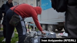 Жителі деокупованого Херсону заряджають мобільні телефони біля генераторів, листопад 2022 року