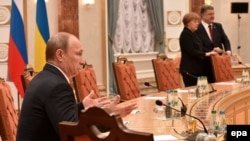 Під час переговорів у Мінську 11 лютого. На передньому плані президент Росії Володимир Путін. На задньому – президент України Петро Порошенко і канцлер Німеччини Анґела Меркель 