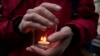 A demonstrator holds a candle as people gather in front of the Supreme Court in Moscow on December 14.