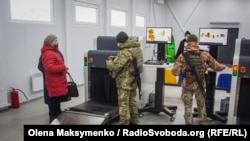Прикордонники перевіряють на інтерскопі речі жінки, яка переходить КПВВ у бік так званої «ЛНР»