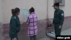  Сотрудники ГУВД города Ташкента заставляют художницу удалить граффити со стены.