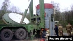 Рабочие извлекают боеголовку советской ядерной ракеты СС-19 из шахты на военной базе возле украинского города Хмельницкий, готовя её к отправке в Россию, апрель 1995 года