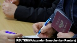 Виборець заповнює документи під час фейкового референдуму про приєднання контрольованої угрупованням «ДНР» території до Росії. Донецьк, 27 вересня 2022 року