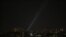 A searchlight looks for drones in the sky over Kyiv during a Russian drone strike on May 19.