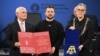 Ukrainian President Volodymyr Zelenskiy (center) receives the Charlemagne Prize for Services to European Unity from Aachen Mayor Sibylle Keupen (right) in Aachen, Germany, on May 14.