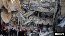 Рафахтагы талкаланган үйдүн алдына чогулган газалыктар. 4-март, 2024-жыл.