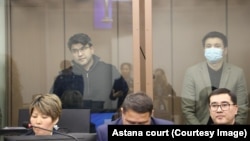 Куандык Бишимбаев сотто көз айнек тагынып, кара күрмө кийип турат. 12-март, 2024-жыл.  