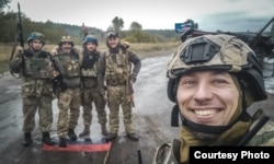 Олександр Шелехань з товаришами, які стоять на прапорі Росії, вересень 2022 року