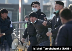 Москвада куч ишлатар тизим ходимлари олиб кетаётган мигрант. Архив.