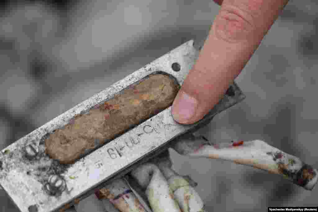 Чубенко показывает на надпись на фрагменте, которая, судя по всему, не содержит ни кириллицы, ни латиницы