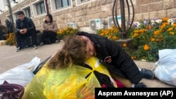 Nagorno-Karabakh - A child sleeps on a bag with clothes and other belongings as people hoping to leave Karabakh gather in Stepanakert, September 25, 2023.