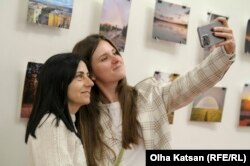 Анна і Наталя роблять селфі на тлі фотографії із своїм будинком