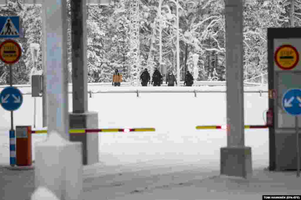 Финские пограничники сопровождают мигрантов, прибывших в пункт &laquo;Рая-Йоосеппи&raquo; в Лапландии. 27 ноября 2023 года. По данным Пограничной службы Финляндии, около 900 просителей убежища из таких стран, как Афганистан, Кения, Марокко, Пакистан, Сомали, Сирия и Йемен, пересекли границу Финляндии из России в ноябре. В октябре эту границу пересек лишь один проситель убежища