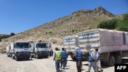 لاری ها و تعدادی از کارمندان برنامه جهانی غذای سازمان ملل که مواد غذایی را به نقاط دور افتاده افغانستان منتقل می کنند 