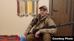 Володимир Коляда біля нагород племінника Андрійка. Березень 2022. Село Софіївська Борщагівка.