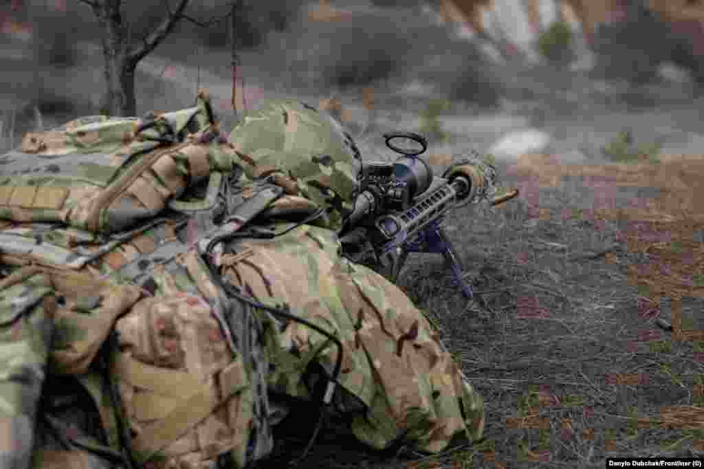 Один з учасників навчання робить постріл із гвинтівки під час тренування.&nbsp; Еланський каже, що багато колишніх снайперів в Україні перекваліфікувалися на операторів FPV-дронів, але він наполягає на тому, що снайпери, як і раніше, незамінні на полі бою. &laquo;Наприклад, ті ж дрони в сильний дощ не літають, а снайпери стріляють за будь-якої погоди&raquo;, &ndash; каже інструктор