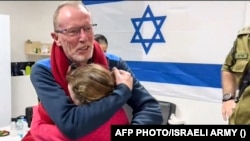 در این عکس دیده می شود که یک دختر 9 ساله به نام امیلی که از سوی گروه حماس آزاد شده پدرش را در آغوش گرفته و هر دو گریه می کنند. 