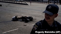 Поліцейський біля уламка ракети після російського ракетного обстрілу в Києві, 29 травня 2023 року