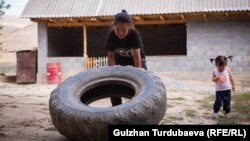 Балбан кыз Арууке Акибаев дөңгөлөк көтөрүп машыгып жатат. Базар-Коргон району. Каба айылы. 