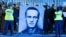 Орусиянын Варшавадагы элчилигинин алдында Алексей Навальныйдын сүрөтүн көтөрүп чыккандар. Польша, 16-февраль, 2024-жыл. 
