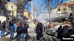 People inspect the damage at the site of a reported Israeli strike in the Mazzeh neighborhood of Damascus, Syria, on January 20. 
