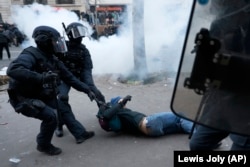 Сотрудники спецназа хватают протестующего во время демонстрации против изменения пенсий. Париж, 19 января 2023 года