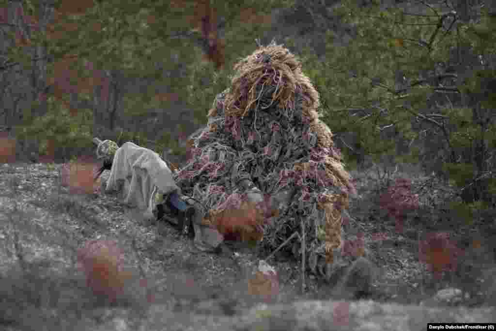 Снайперка Катерина (ім&rsquo;я змінене), замаскована у &laquo;кікімору&raquo;. Катерину навчають маскуванню, що є окремим мистецтвом. &laquo;Якщо ти вибрала позицію, ти не завжди можеш побачити, наприклад, свої ноги, зброю, &ndash; пояснює Катерина &ndash; Наприклад, пристебнутий ніж на поясі може блищати, потрібно це враховувати&raquo; &ndash; каже вона. Під час курсу &laquo;інструктори ходять, дивляться наші позиції, вказують на помилки, фотографують. Ми аналізуємо це все&raquo;, &ndash; розповідає Катерина