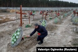 Заместитель мэра Бучи Сергей Шепетько возлагает цветы на могилы погибших в Буче, чьи личности остались неустановленными