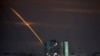 Rockets launched from Russia's Belgorod region streak across the sky at dawn in Kharkiv, Ukraine, early on March 24.