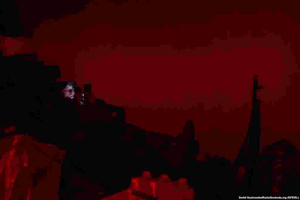 Військовий спілкується з родиною у світлі червоного ліхтарика. Через декілька годин&nbsp;&ndash;&nbsp;він і його підрозділ братиме участь у штурмових&nbsp;&nbsp;діях на північ від Бахмута. Травень 2023 року&nbsp;