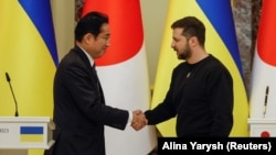  Ukrainian President Volodymyr Zelenskiy (right) greets Japanese Prime Minister Fumio Kishida in Kyiv on March 21. 
