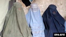 آرشیف- شماری از زنان بی بضاعت در انتظار دریافت کمک در قطار نشسته اند. 