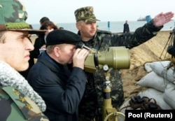 Президент України Леонід Кучма дивиться на російську дамбу, яку споруджували з Краснодарського краю Росії в бік українських територіальних вод. Прикордонна застава на острові Тузла, 23 жовтня 2003 року