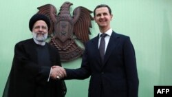 بشارالاسد رئیس جمهور سوریه (راست) حین مصافحه با رئیس جمهور ایران ابراهیم رئیسی در دمشق پایتخت سوریه