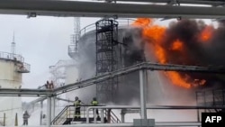 Рятувальники гасять пожежу на нафтобазі внаслідок атаки безпілотника в Клинцях Брянської області на тлі повномасштабного вторгнення Росії в Україну. 18 січня 2024 р.