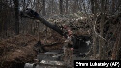 Українські військові біля самохідної гаубиці 2S3 поблизу Бахмута, Донецька область, Україна, 25 березня 2024 року