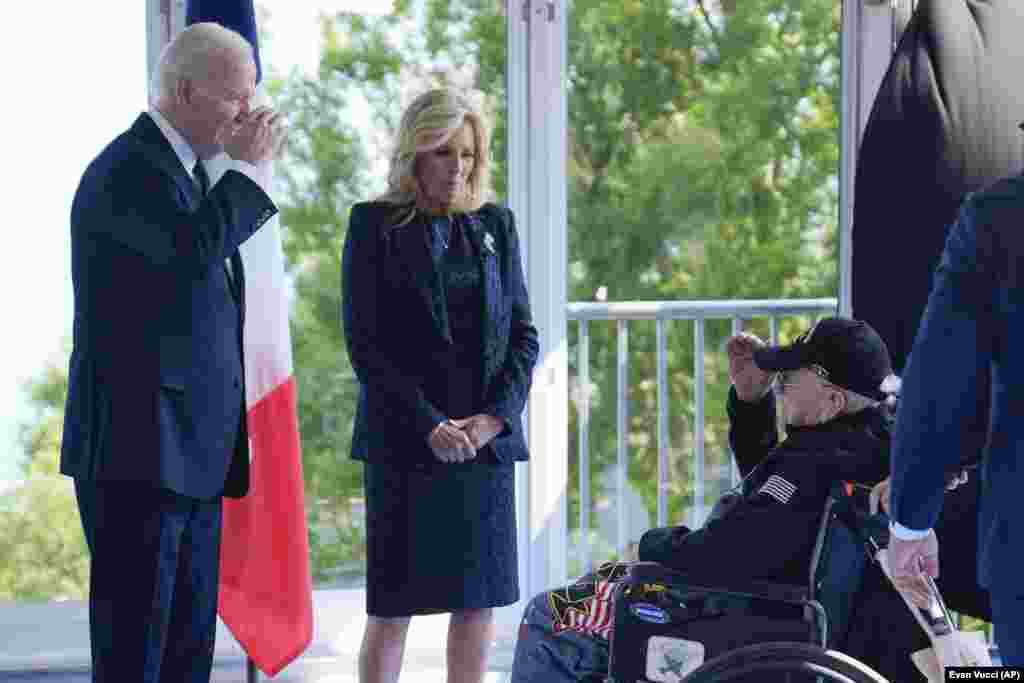 Джо Байден вітає ветерана Другої світової війни, а Джилл Байден дивиться на нього. &laquo;Ми повинні пам&rsquo;ятати, що той факт, що вони були тут героями того дня, не звільняє нас від того, що ми маємо робити сьогодні. Демократія ніколи не гарантована. Кожне покоління має її зберігати, захищати та боротися за неї. Це випробування віками&raquo;, &ndash; сказав Байден у своєму виступі