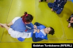 Айжан Кадырбекова окуучуларына ыкмаларды көрсөтүп жатат.