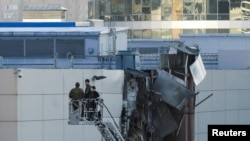 Moskwada 18-nji awgustda bir ukrain dronynyň urlup ýykylandygynyň habar berilmeginiň yz ýany, derňewçiler zeper ýeten üçekde iş alyp barýar. 