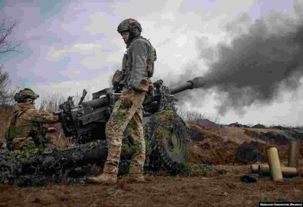 Ukrainian soldiers fire an M119 howitzer toward Russian positions.
