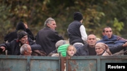 ARMENIA -Refugees from Nagorno-Karabakh ride in the back of a truck as they arrive in the border village of Kornidzor, September 26, 2023.