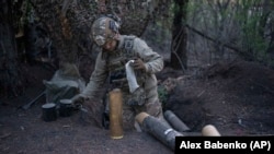 Український військовослужбовець бригади «Азов» готує снаряди для гаубиці ОТО Melara Mod 56 на передовій на Кремінському напрямку Донецької області, Україна, 11 квітня 2024 року