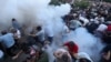 ARMENIA - Demonstrators react to stun grenades fired by law enforcement officers during a protest against Armenian Prime Minister Nikol Pashinian in Yerevan, June 12, 2024. 