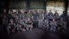 Ukrainian President Volodymyr Zelenskiy (center), during a trip to the Donetsk region, poses for a photo with Ukrainian troops in an image released on June 26.